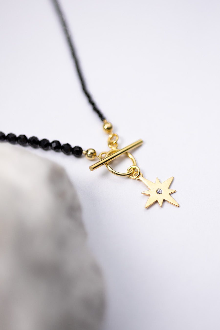 Czarny naszyjnik ze spineli i zawieszką róża wiatrów