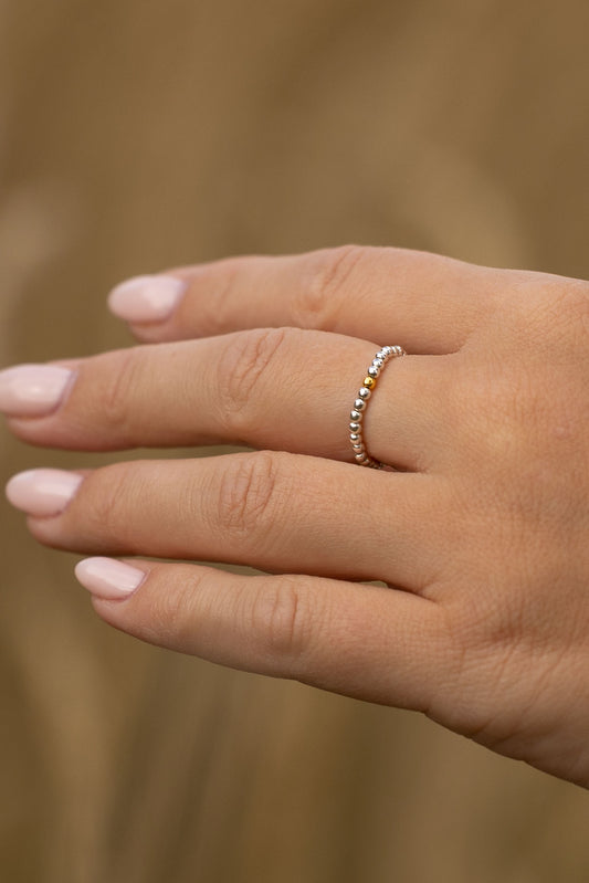 Srebrny pierścionek elastyczny z pozłacaną kulką